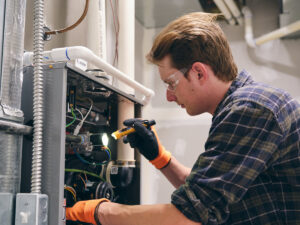 image of HVAC technician repairing a furnace.