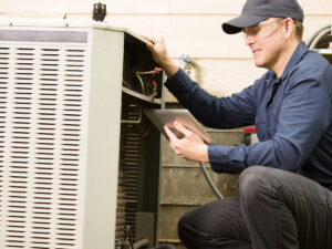 image of HVAC technician fixing an air conditioner.