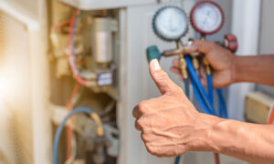 Man giving thumbs up while checking Air conditioner system