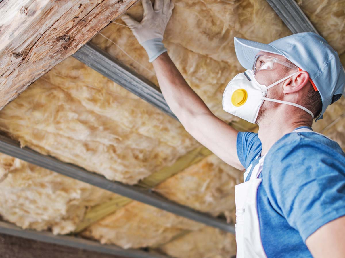 An image of a man checking attic insulation.