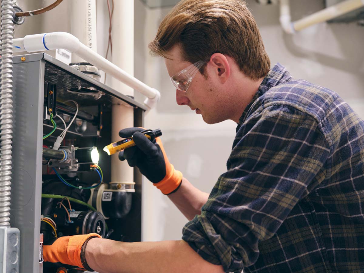 An image of a professional fixing a commercial HVAC system.